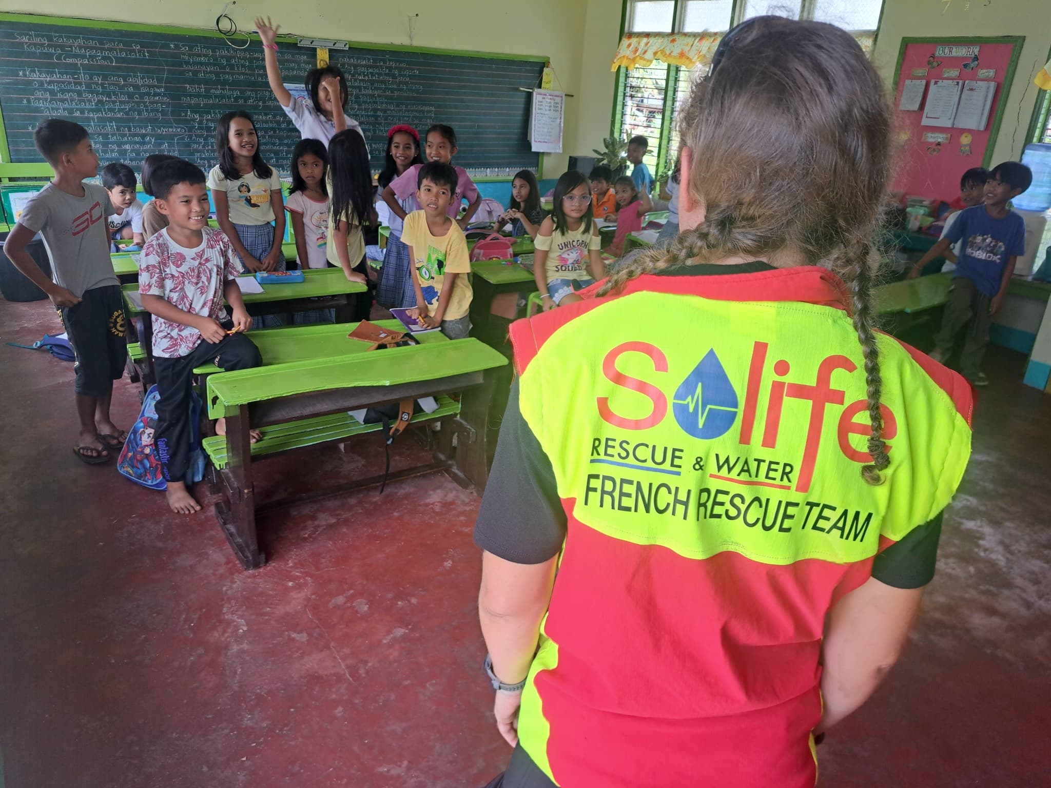 Une membre de l'équipe SOLIFE auprès d'écoliers sur l'île de Leyte, aux Philippines